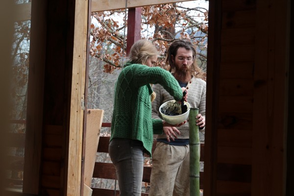 Amelia puts bio-char into her and Tony's water filter. Photo Credit: National Geographic Television/Lindsay Cooper