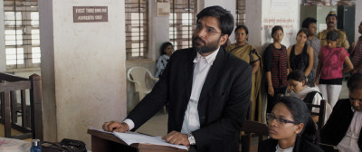 Vivek Gomber (standing) stars as Vinay Vora in Court, a film by Chaitanya Tamhane. Photo courtesy of Zeitgeist Films.